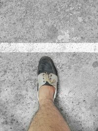 Low section of man standing on road