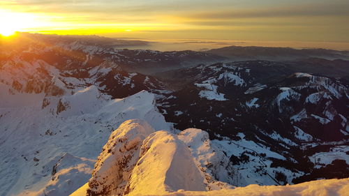 Scenic view of snowcapped mountains against sky during sunset