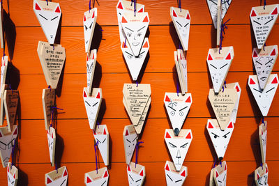 Full frame shot of prayer blocks hanging on wooden wall at temple