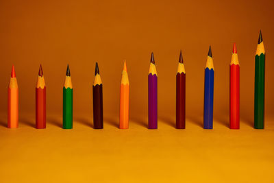 Close-up of colored pencils against yellow background