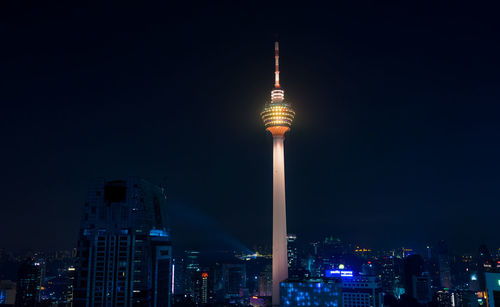 Communications tower against sky in city at night