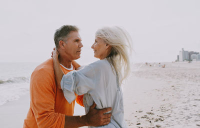 Side view of couple romancing at beach