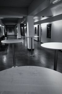 Empty chairs and tables in illuminated building