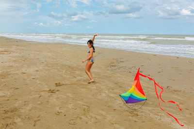 Rear view of woman standing at beach