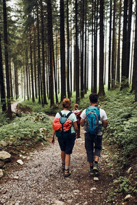 Family with backpacks hiking in a mountains actively spending summer vacation together
