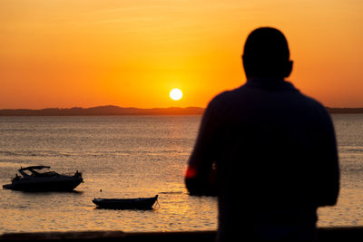 People are enjoying the sunset at porto da barra in the city of salvador, bahia.
