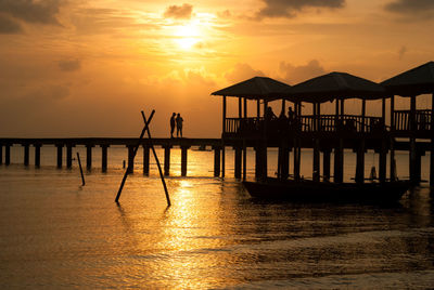 Pier on sea at sunset