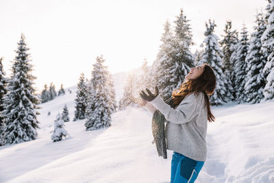 Rear view of woman standing on snow