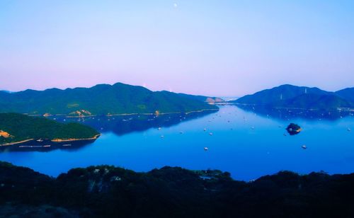 Scenic view of lake and mountains against blue sky