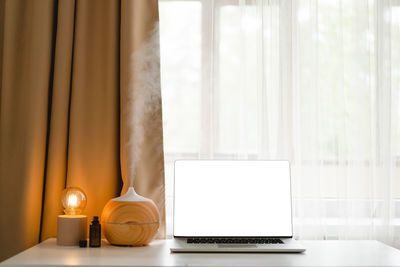 Aroma oil diffuser in work place, laptop and home decor