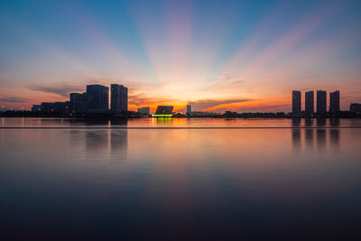 Bridge over river against sky at sunset