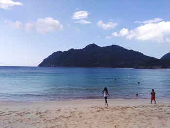 People on beach against sky