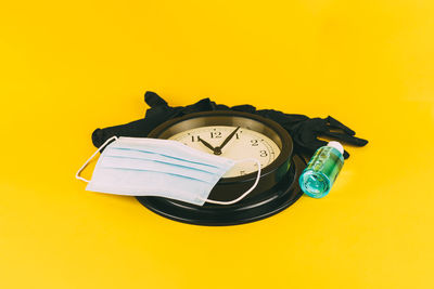 High angle view of clock on yellow background