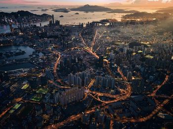 High angle view of city lit up at sunset