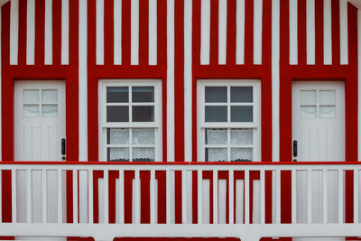 Typical colourful houses with red and white stripes in costa nova - aveiro against sky