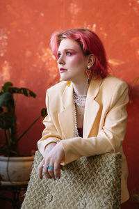 Young woman standing against wall