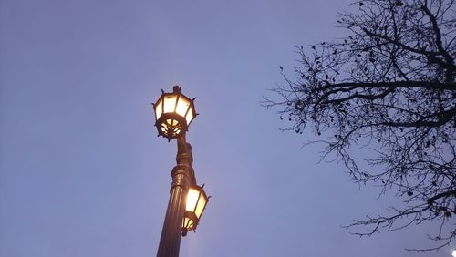 Low angle view of illuminated street light against sky