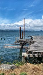 Wooden posts on beach against sky