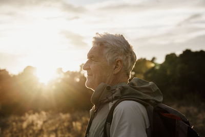 Senior man in warm clothing looking at sunset