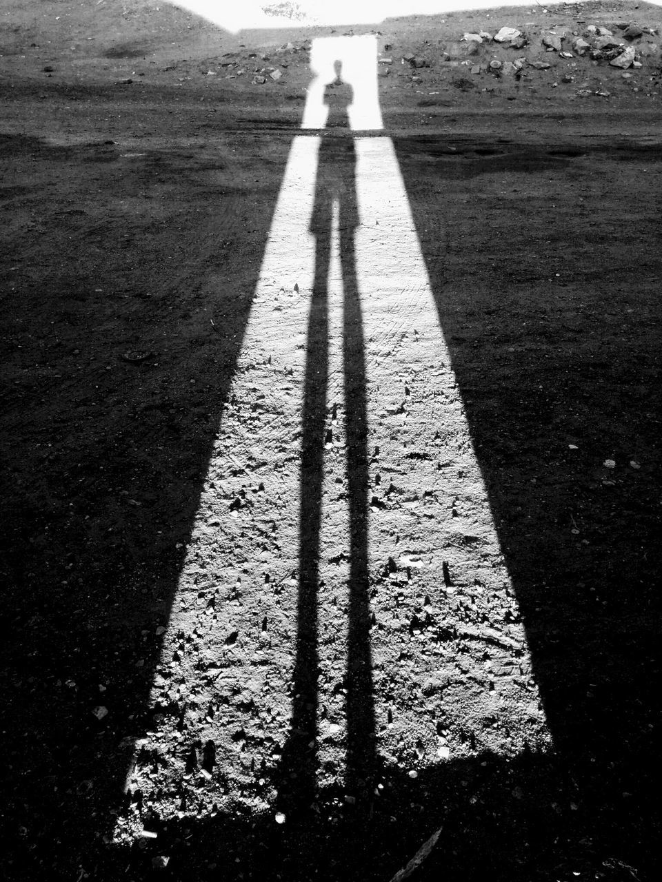 SHADOW OF MAN ON STREET