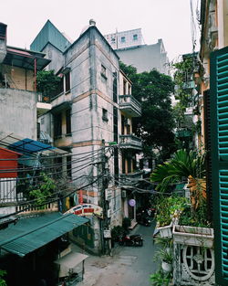 Street by buildings in city against sky