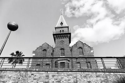 Low angle view of bell tower amidst buildings against sky