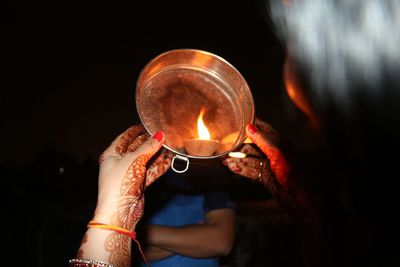 Midsection of man holding illuminated candles