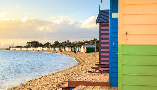 Beach huts by sea against sky