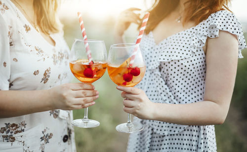 Midsection of woman drinking glass