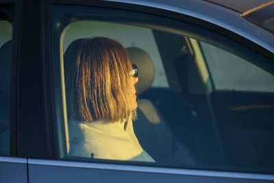 Rear view of woman looking through window