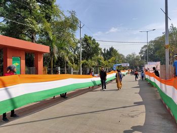 People on street in city against sky