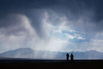 People on mountain landscape against sky