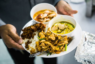 Midsection of person holding food served on table