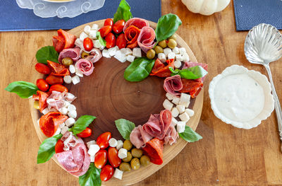 Italian charcuterie wreath with prosciutto, mozzarella, tomato, basil, salami, and olives