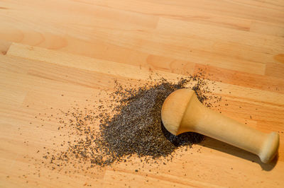 High angle view of ground black peppers on wooden table