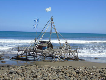 Sailboat on beach against clear sky