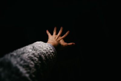 Person hand against black background