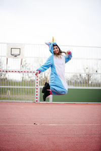 Portrait of smiling man jumping on fence