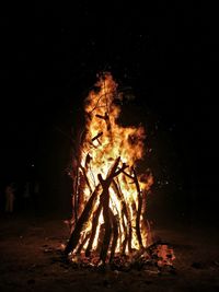 Close-up of bonfire on field against sky at night