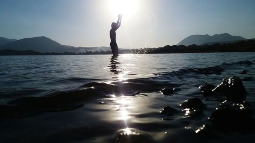 Man and woman in sea against sky