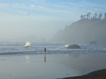 Man standing on beach against sky