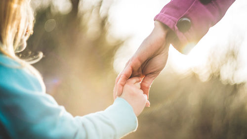 Close-up of girl holding mother hand