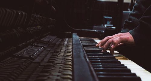 Close-up of hand playing piano