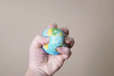 Close-up of person holding hand over white background