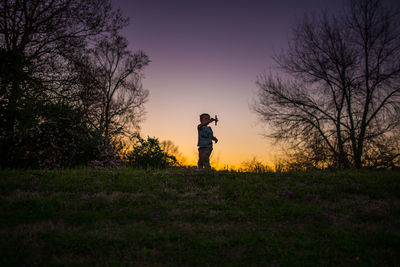 Little boy playing airplane silohette summer sunset purple yellow