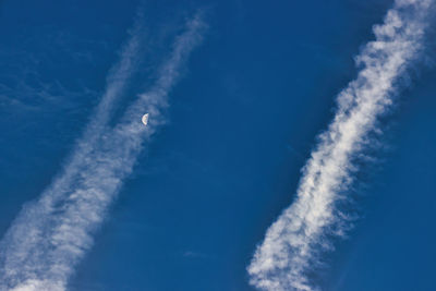 Low angle view of vapor trail against blue sky