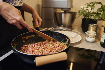 Woman cooking sauce bolognese in kitchen