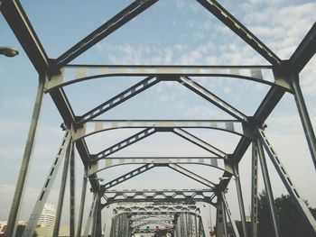 Low angle view of bridge against cloudy sky