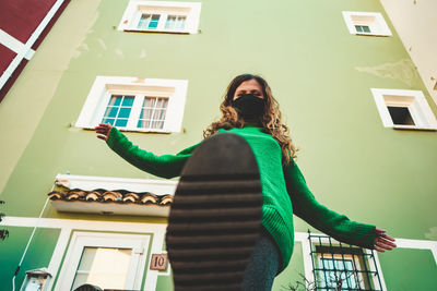 Rear view of woman standing against building