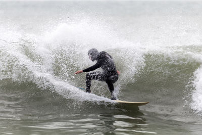 Man surfing in sea against sky